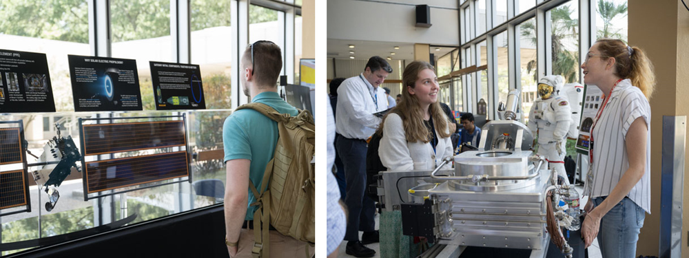 People visit exhibit tables and displays to learn more about space exploration.